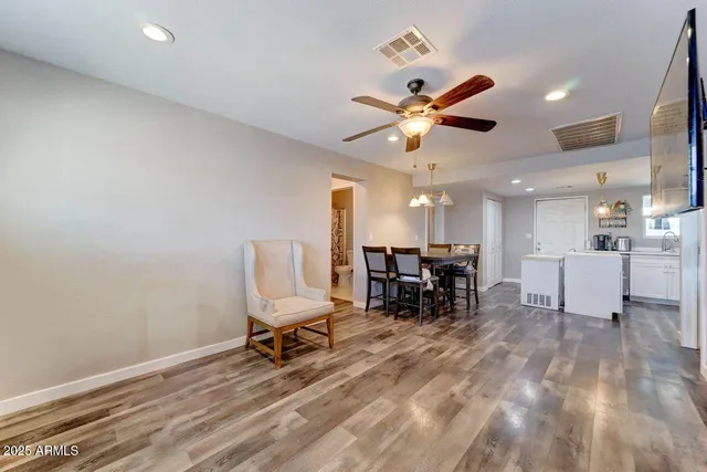 a view of a workspace with furniture and a ceiling fan