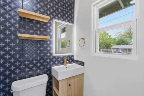 a bathroom with a sink mirror vanity and toilet