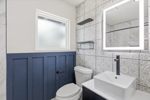 a bathroom with a sink a toilet and window