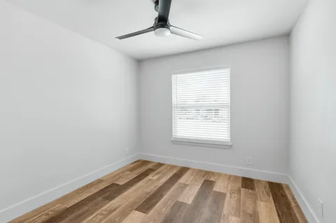 a view of a room with wooden floor and fan