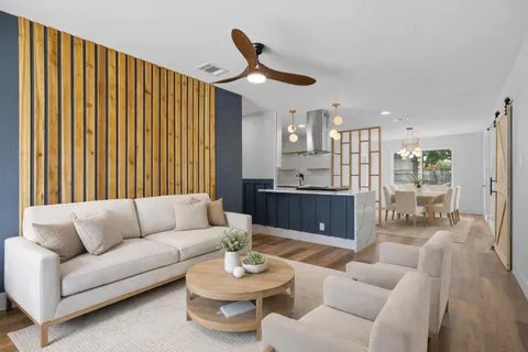a living room with furniture and a wooden floor