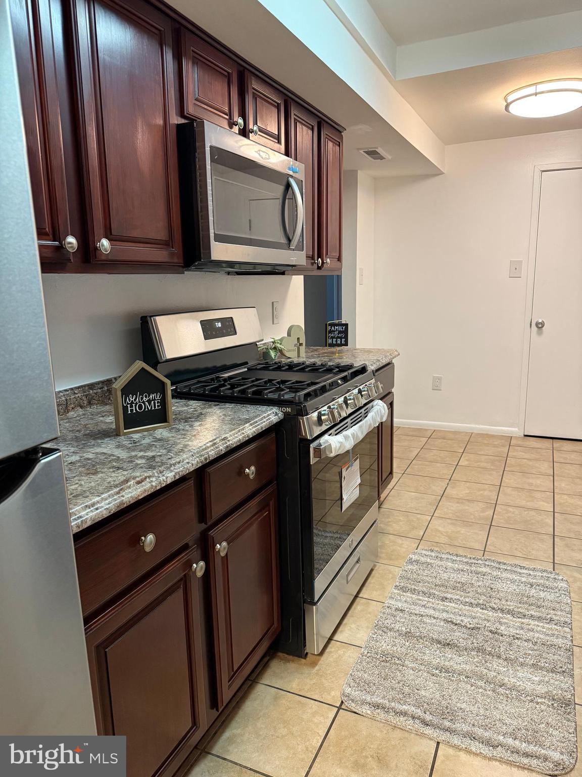 10244 Prince Place, Unit 21T3 Upper Marlboro, MD 20774 - Photo 12 of 64 a kitchen with granite countertop a stove top oven cabinetry a sink and dishwasher
