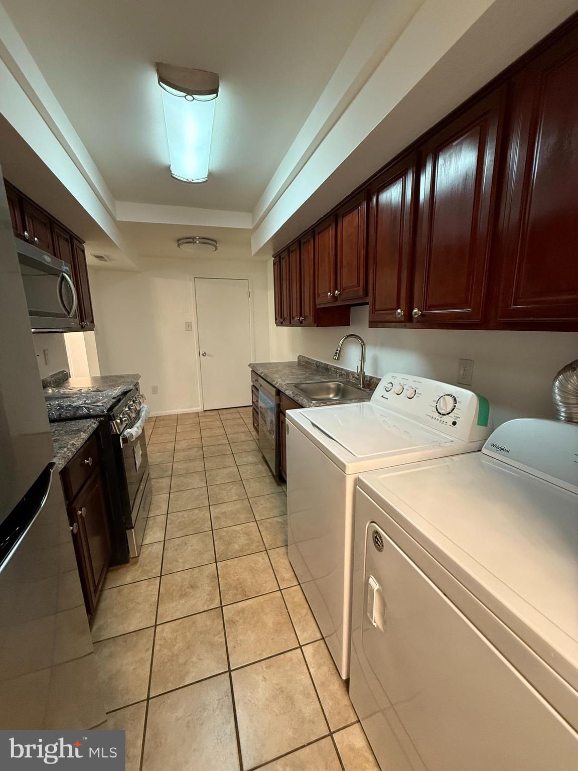 10244 Prince Place, Unit 21T3 Upper Marlboro, MD 20774 - Photo 14 of 64 a kitchen with a sink a stove and a microwave oven