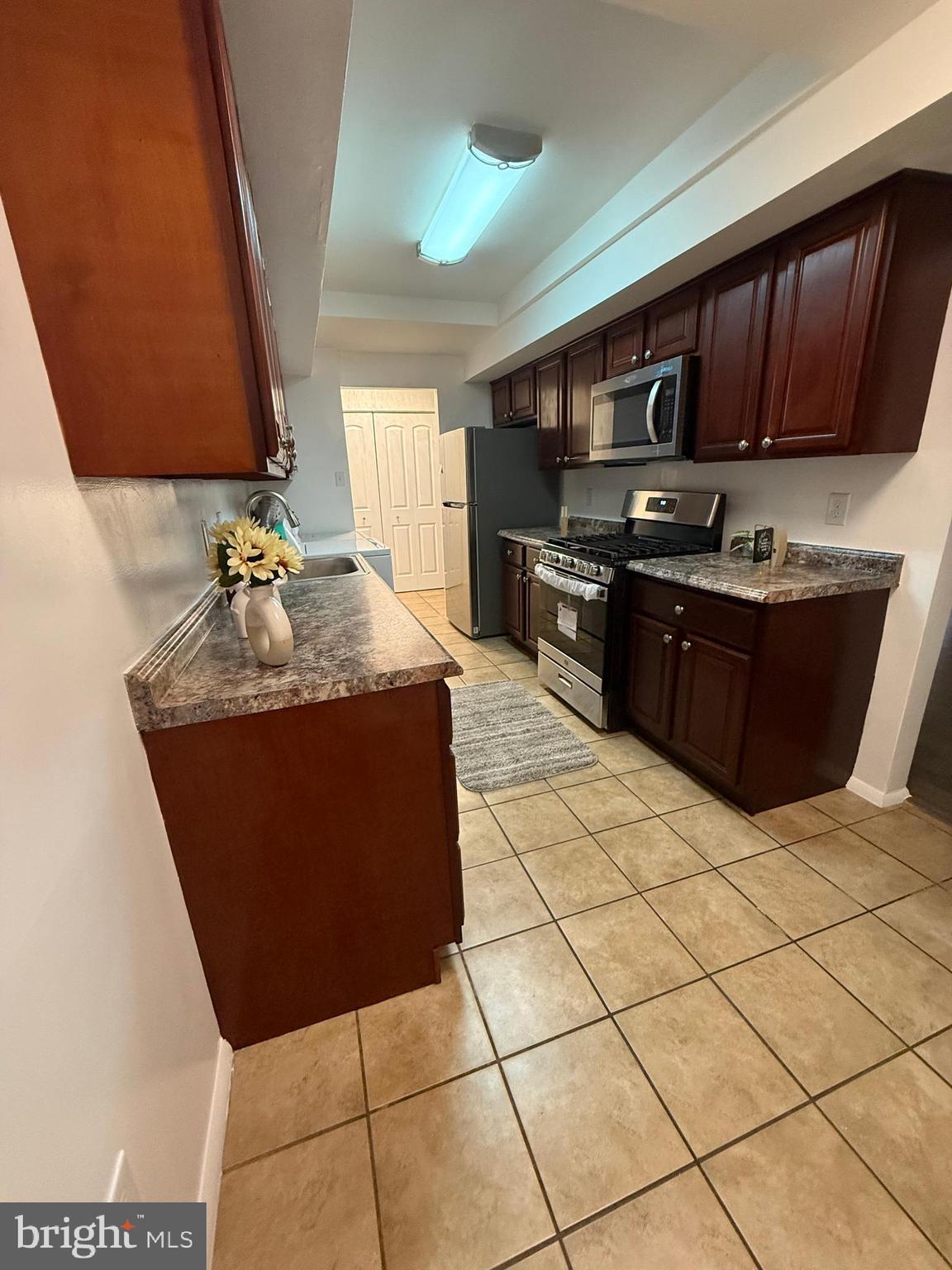 10244 Prince Place, Unit 21T3 Upper Marlboro, MD 20774 - Photo 18 of 64 a kitchen with stainless steel appliances granite countertop a stove a sink and a microwave