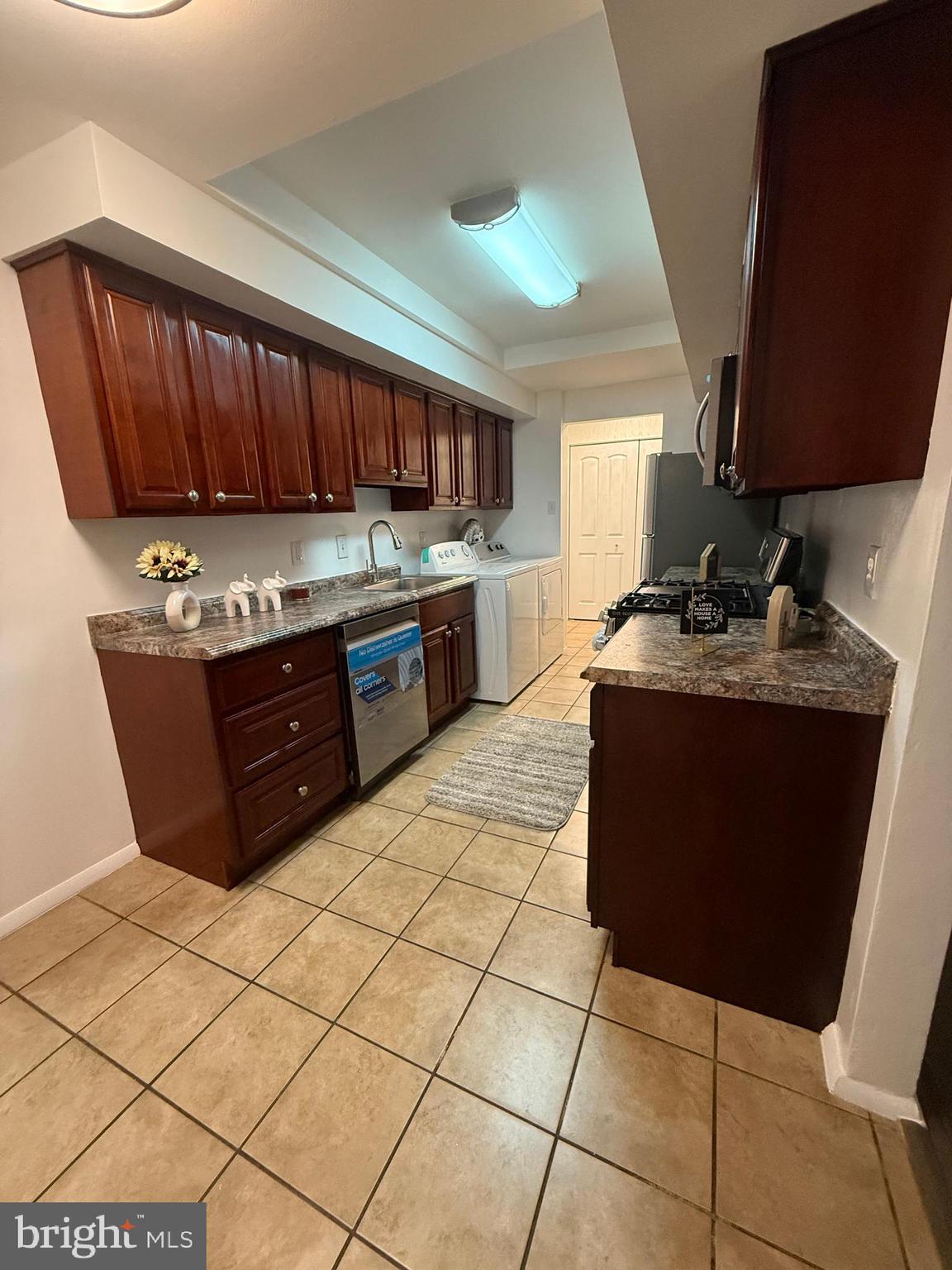 10244 Prince Place, Unit 21T3 Upper Marlboro, MD 20774 - Photo 19 of 64 a kitchen with a sink a stove a microwave and cabinets