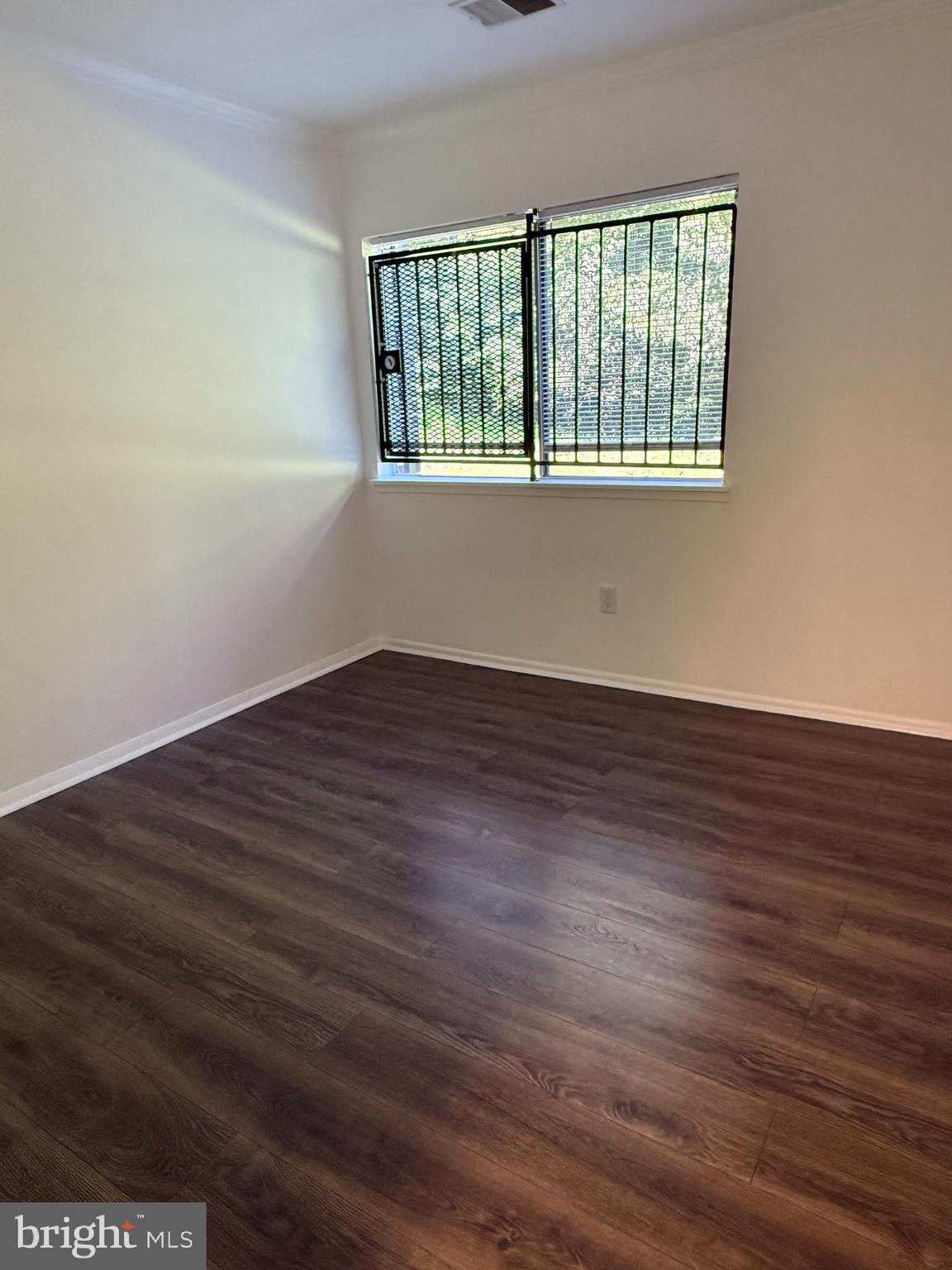 10244 Prince Place, Unit 21T3 Upper Marlboro, MD 20774 - Photo 37 of 64 a view of an empty room with wooden floor and a window