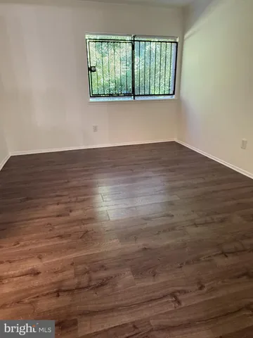a view of a hallway with wooden floor and a window
