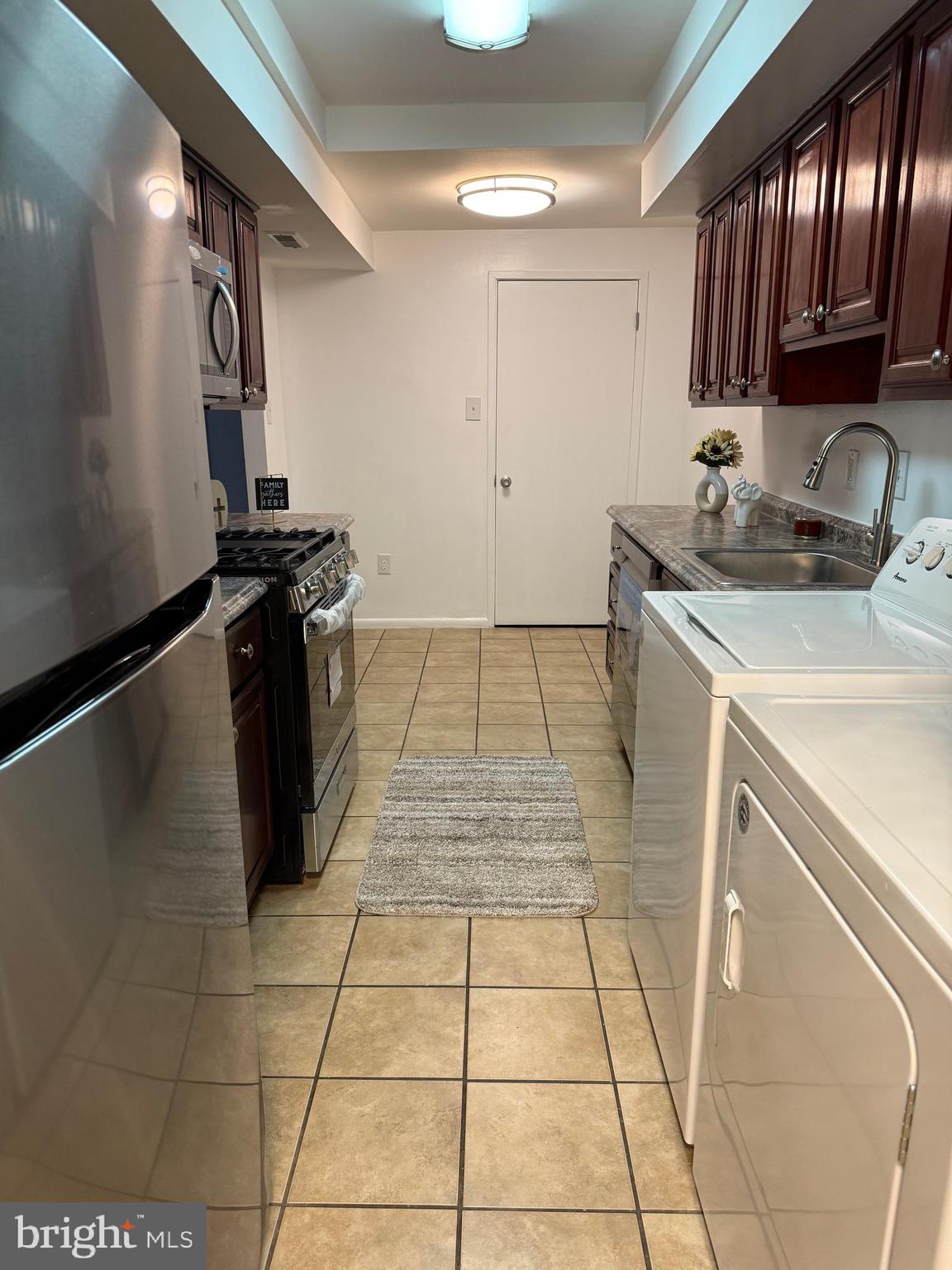 10244 Prince Place, Unit 21T3 Upper Marlboro, MD 20774 - Photo 10 of 64 a kitchen with a sink a stove and a refrigerator