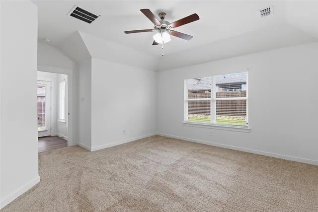 a view of an empty room with a window and a ceiling fan
