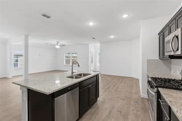 a kitchen with kitchen island a sink stove and cabinets