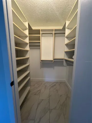 a view of walk in closet with empty racks