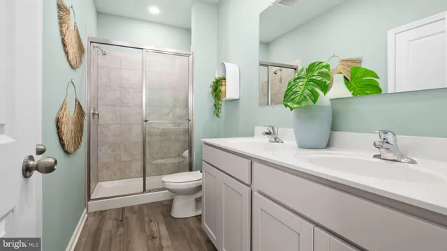 a bathroom with a granite countertop sink a toilet and shower
