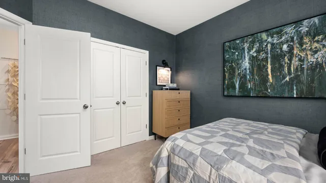 a bedroom with a bed and a refrigerator