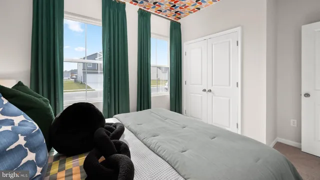 a bedroom with a bed and a window with a chair