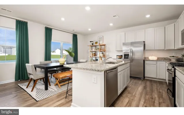 a kitchen with a table chairs refrigerator and cabinets