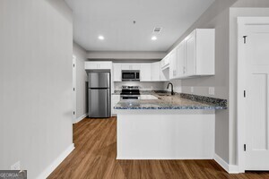 86 South Forest Avenue, Unit A Hartwell, GA 30643 - Photo 13 of 27 a kitchen with stainless steel appliances granite countertop a stove a sink and a refrigerator