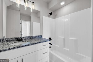 86 South Forest Avenue, Unit A Hartwell, GA 30643 - Photo 19 of 27 a bathroom with a granite countertop sink a mirror and a bathtub