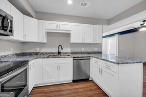 86 South Forest Avenue, Unit A Hartwell, GA 30643 - Photo 5 of 27 a kitchen with stainless steel appliances granite countertop a sink and dishwasher a stove top oven with white cabinets