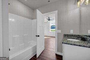 86 South Forest Avenue, Unit A Hartwell, GA 30643 - Photo 6 of 27 a bathroom with a granite countertop sink a bathtub and shower