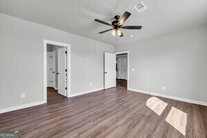 86 South Forest Avenue, Unit A Hartwell, GA 30643 - Photo 8 of 27 a view of an empty room with wooden floor and a ceiling fan