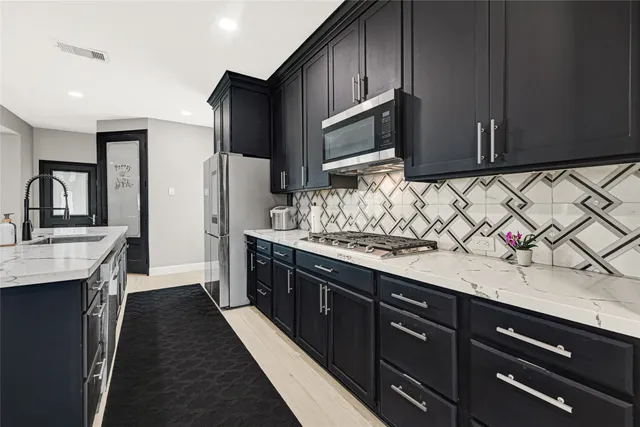 a kitchen with stainless steel appliances wooden cabinets and a sink
