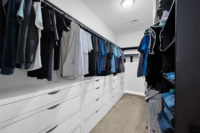 a view of walk in closet with clothes and shoes