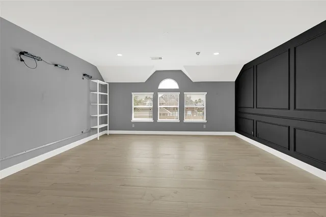 a view of an empty room with closet and a window