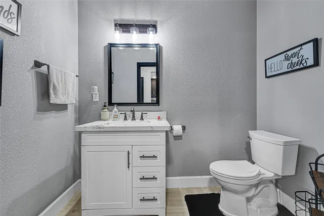 a bathroom with a toilet a sink and mirror