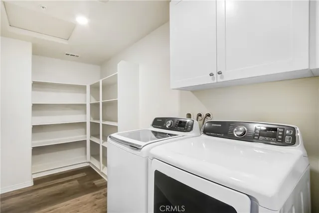 a utility room with dryer washer and a view of living room