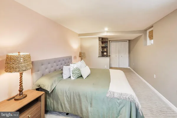 a spacious bedroom with a bed and a lamp