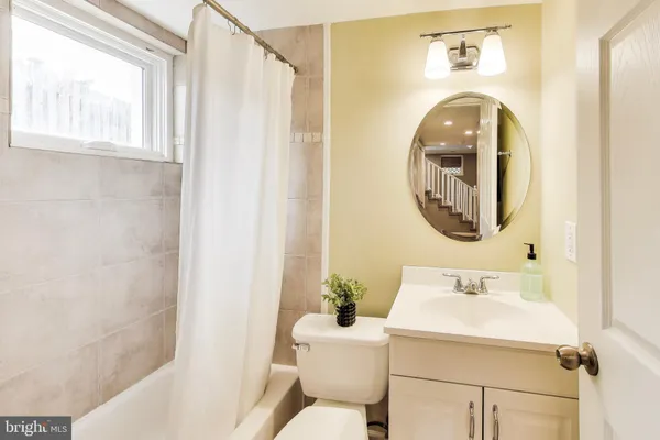 a bathroom with a sink mirror and a toilet