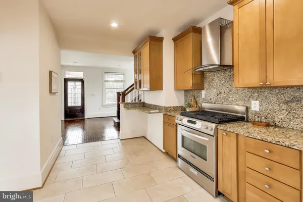 a kitchen with stainless steel appliances granite countertop a stove a sink and a refrigerator