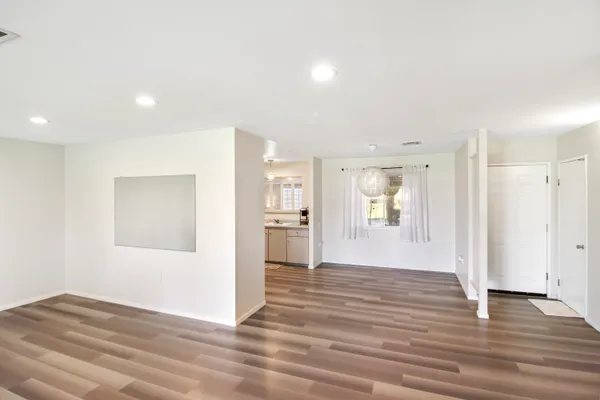 a view of a big room with wooden floor and windows