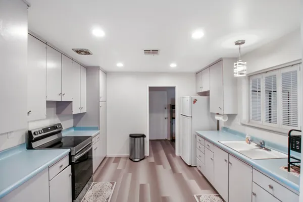 a kitchen with stainless steel appliances a sink stove refrigerator and cabinets