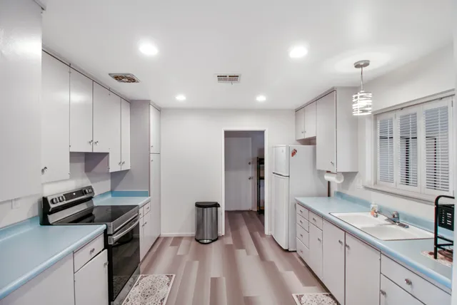 a kitchen with stainless steel appliances a sink stove refrigerator and cabinets