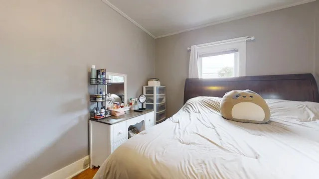 a bedroom with a bed a window and a flat screen tv