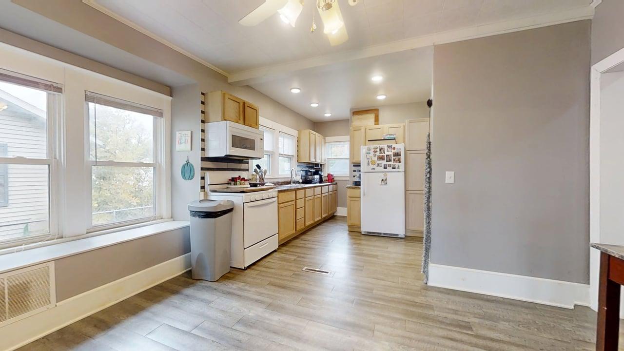 1311 West Hill Street Champaign, IL 61821 - Photo 6 of 25 a kitchen with granite countertop a refrigerator oven a sink dishwasher and white cabinets with wooden floor