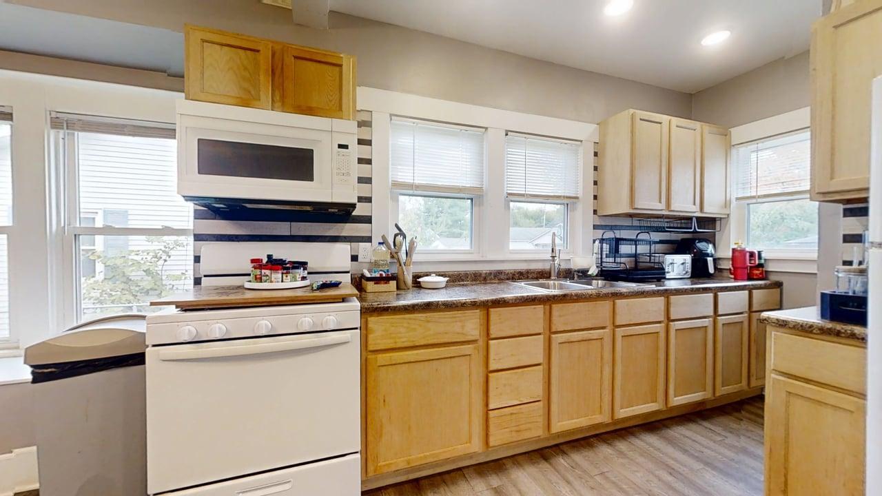 1311 West Hill Street Champaign, IL 61821 - Photo 9 of 25 a kitchen with granite countertop white cabinets and white appliances