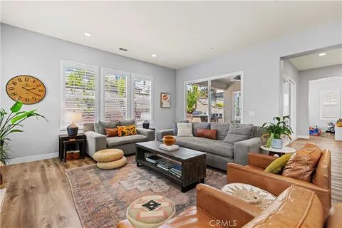 a kitchen with stainless steel appliances granite countertop a refrigerator a stove and a dining table with wooden floor