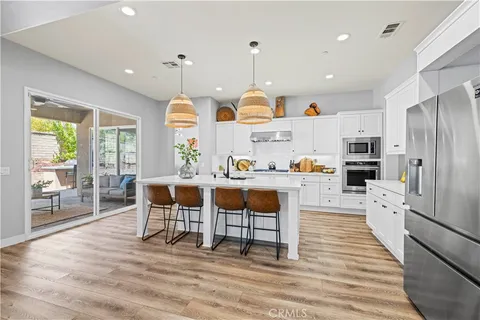 a living room with lots of furniture and a hard wood floor