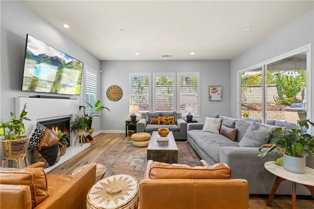 a living room with furniture a fireplace and a flat screen tv