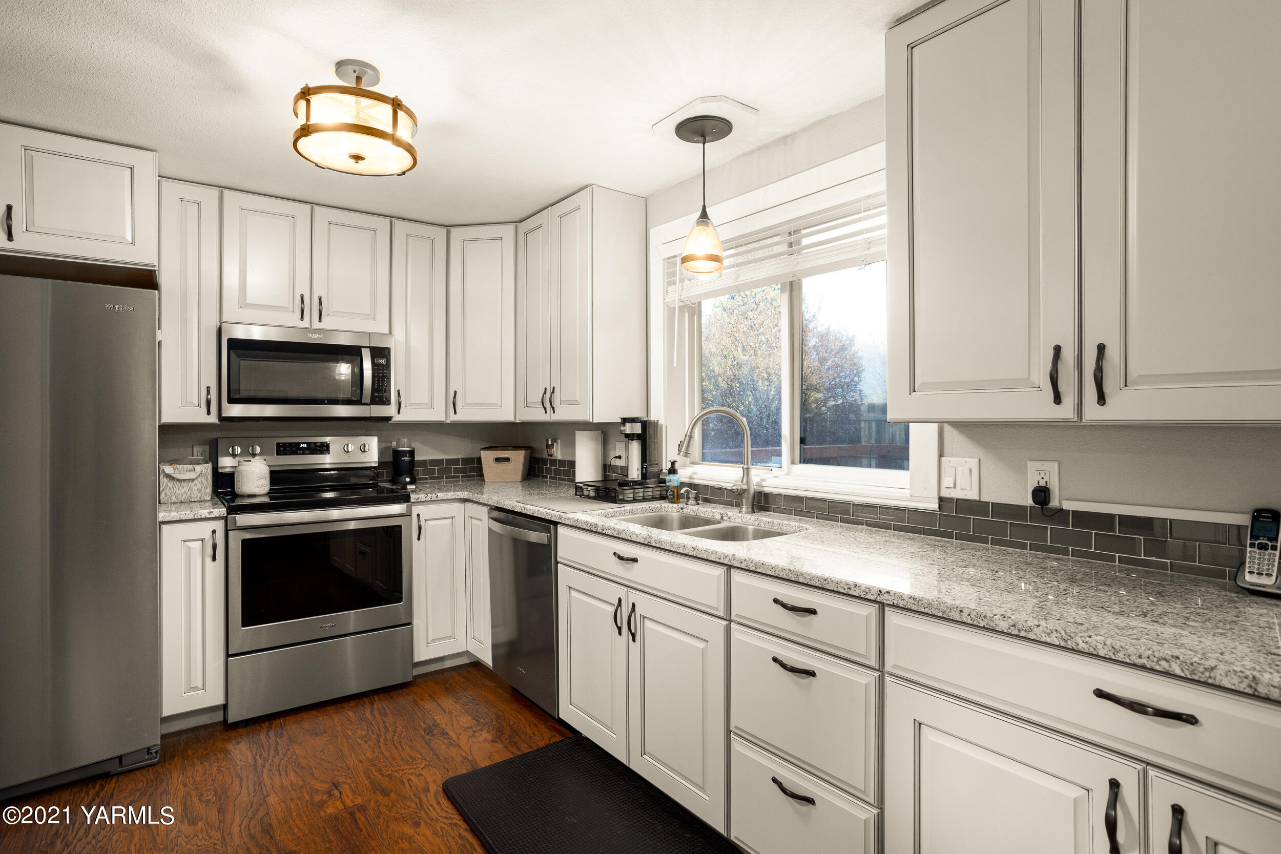 1517 South 32nd Avenue Yakima, WA 98902 - Photo 8 of 21 a kitchen with granite countertop white cabinets stainless steel appliances and a sink