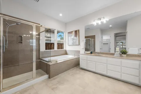 a spacious bathroom with a shower a sink and mirror