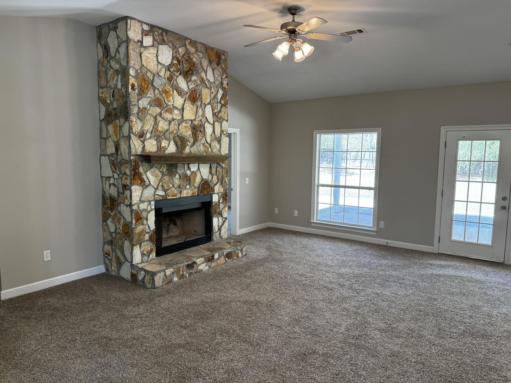 6102 Holloway Road Baker, FL 32531 - Photo 9 of 28 an empty room with a fireplace and fan