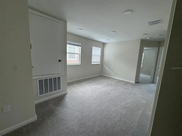 an empty room with windows and closet