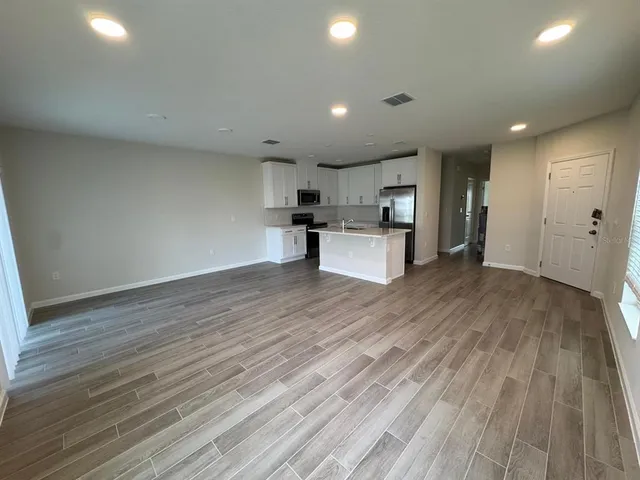 a view of kitchen with wooden floor and electronic appliances
