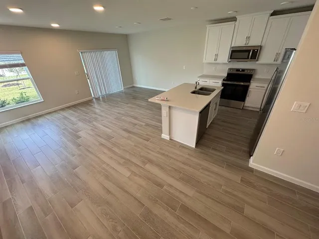 a kitchen with granite countertop a stove and a wooden floor