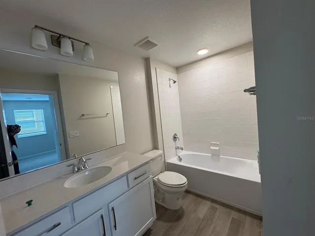a bathroom with a double vanity sink toilet mirror and bathtub