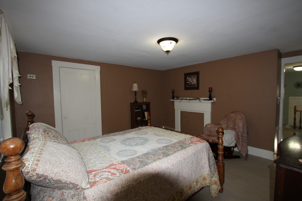 47 Locust Street Merrimac, MA 01860 - Photo 18 of 24 a bedroom with a bed and a chair