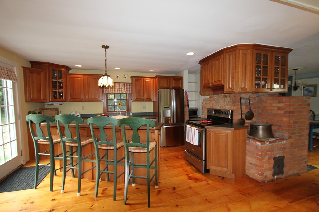 47 Locust Street Merrimac, MA 01860 - Photo 5 of 24 a kitchen with stainless steel appliances kitchen island granite countertop a dining table chairs and a refrigerator